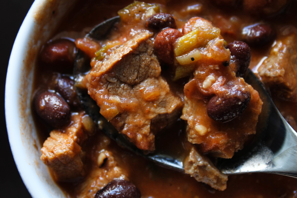 OS beef chili above small bowl with spoon up close